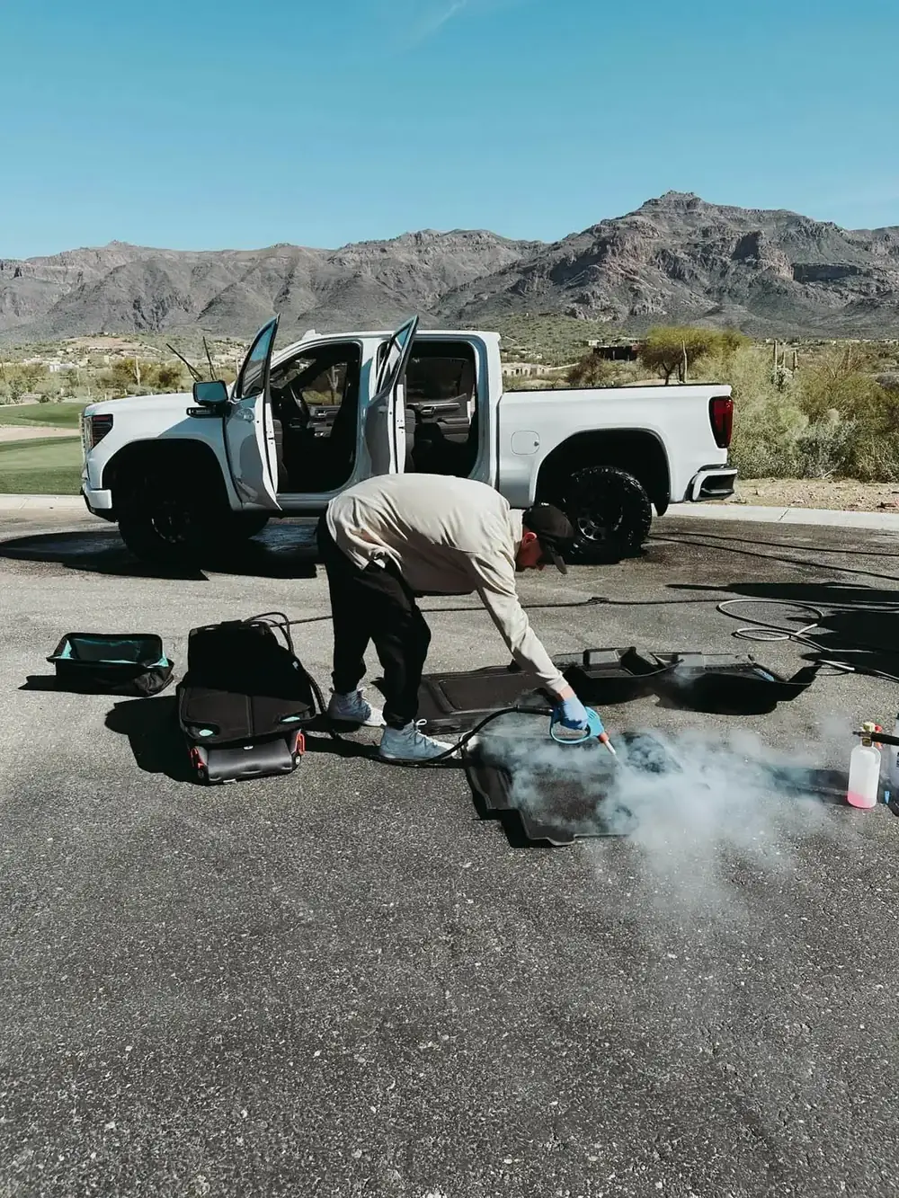 Desert Steam technician steam cleaning truck floor mats on location in Arizona